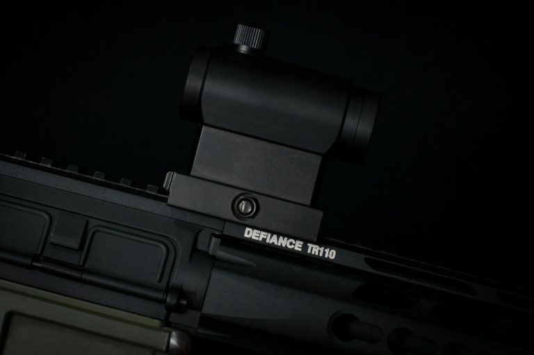 Detailed view of a rifle scope mounted on a tactical firearm, showcasing precision equipment.